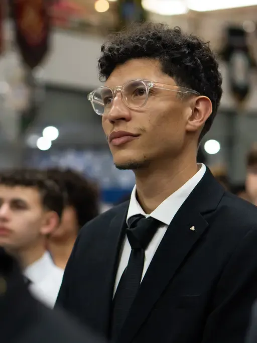 Sênior DeMolay de terno acompanha uma cerimônia em meio aos jovens do Capítulo